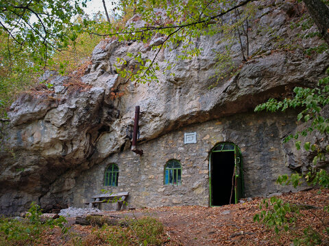 Historic stone cave shelter built beneath a massive limestone rock overhang at Odvas-ko in the Bukk Mountains, northern Hungary.