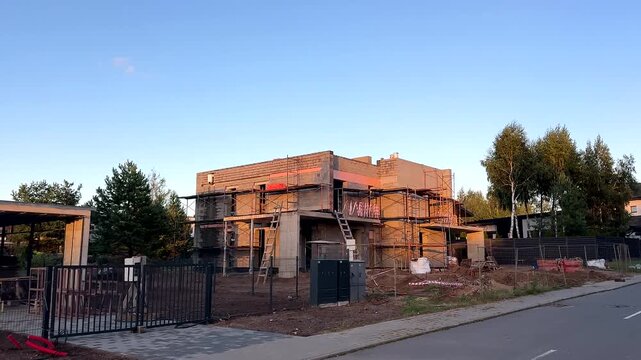 Construction of modern duplex house in Scandinavian barn style. Two houses are under construction in suburb neighborhood. Modern barn-style duplex suburb building. Barndominium and farmhouse duplex.