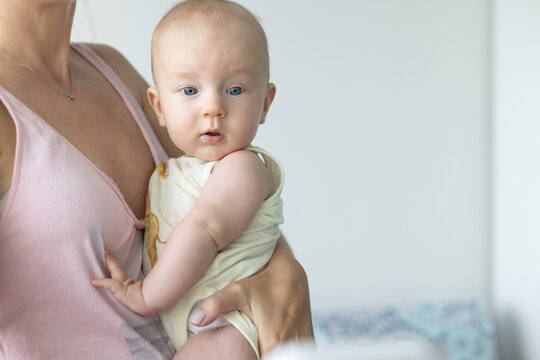 Portrait of the baby of 4-5 months in mothers hands. Closeup, selective focus.