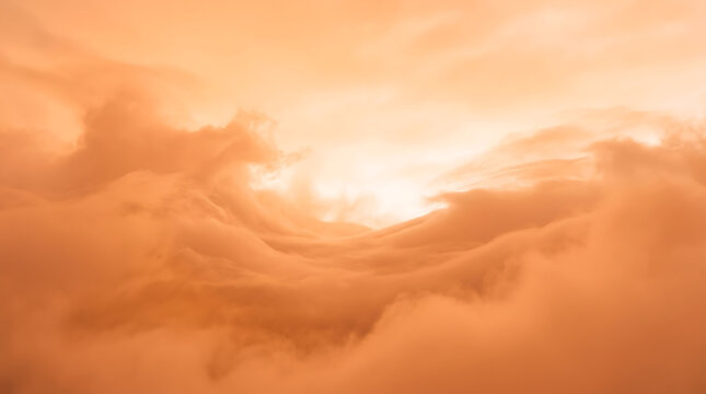 Warm sunlight breaking through a dramatic orange and peach colored cloudscape