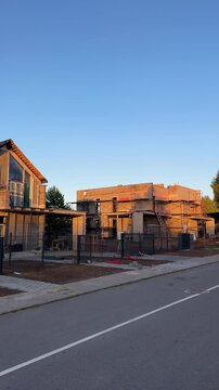 Construction of modern duplex house in Scandinavian barn style. Two houses are under construction in suburb neighborhood. Modern barn-style duplex suburb building. Barndominium and farmhouse duplex.