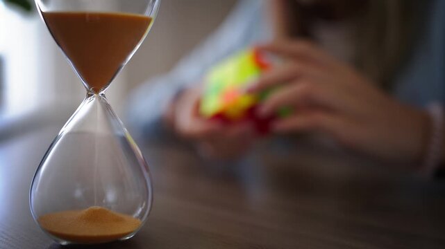 Hourglass counting down while young girl solves colorful puzzle in background, symbolizing time management, patience, concentration, logical thinking and problem-solving skills