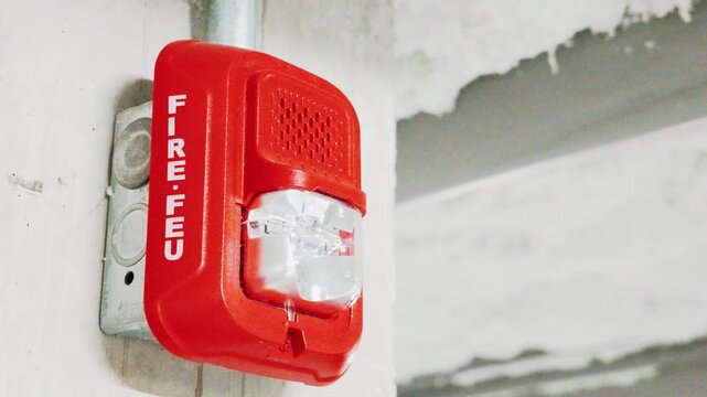Bilingual Fire Alarm Horn Strobe Mounted on Concrete Wall