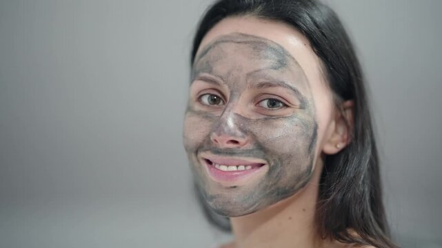 Happy smiling woman with a black face mask on her face looking at camera