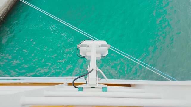 Marine Searchlight Mounted Over Turquoise Ocean Water on Ship Deck