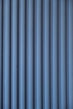 Blue vertical panels create a simple and clean pattern on a wall in an indoor space