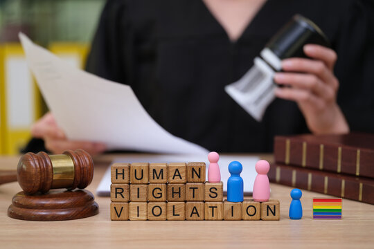 Courtroom scene shows a judge with a gavel discussing human rights violations. Colorful figures and a rainbow flag symbolize diversity and advocacy for equality and justice.