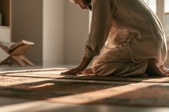 Muslim man praying sujud at home on rug