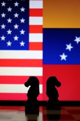 United States and Venezuela flags behind chess knight pieces. Oil negotiations, economic sanctions, and geopolitical relations concept. © Blossom Stock Studio