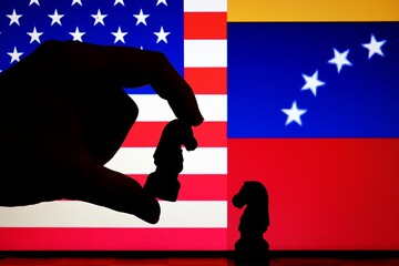 United States and Venezuela flags behind chess knight pieces. Oil negotiations, economic sanctions, and geopolitical relations concept. © Blossom Stock Studio