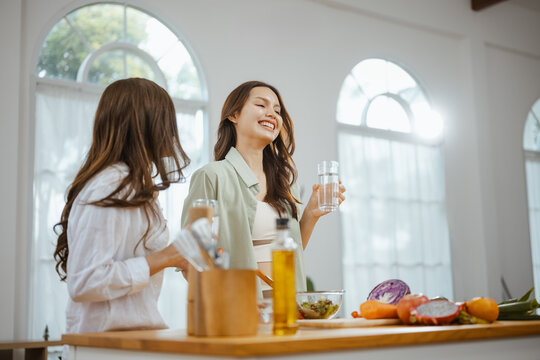 The broad smiles suggest drinking as water supports hydration in a healthy drinking water theme, while raised glasses suggest drinking as water supports hydration in a healthy drinking water setting.