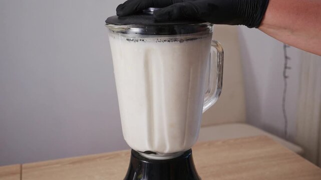 Preparing raw blanched almonds with water in glass blender. Process of making fresh plant based almond milk, nut cream or almond cheese ricotta at home.