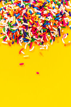 Colorful Candy Sprinkles on Yellow Background