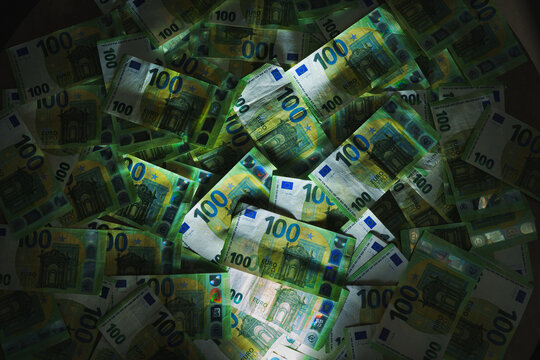 100 euro banknotes in dramatic light.