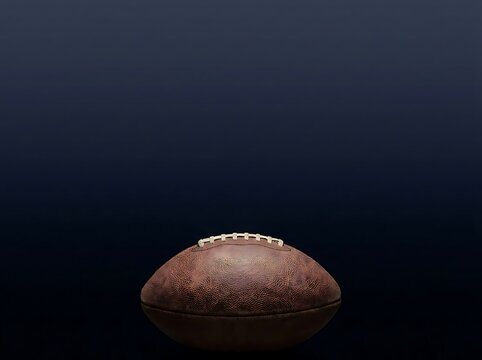 American football ball on dark blue background