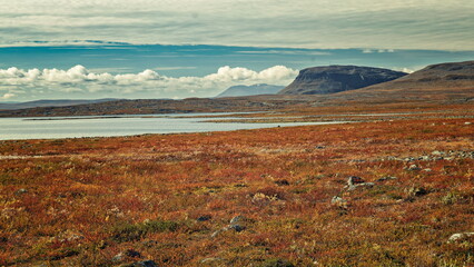 Enontekio, Finland - 27.08.2026: Vast arctic tundra landscape with a calm lake and flat-topped mountains under a cloudy sky in late summer © Andrei