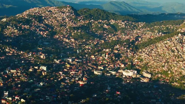 Drone turns right over Baguio City at sunrise in Benguet highlands, Philippines