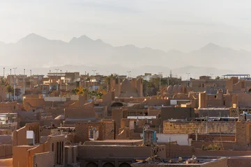 Meybod city, Yazd Province, Iran. View of traditional iranian architecture in sunset with mountains © Inna