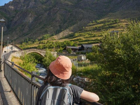 Woman Hiking Through Mountain Village with Backpack