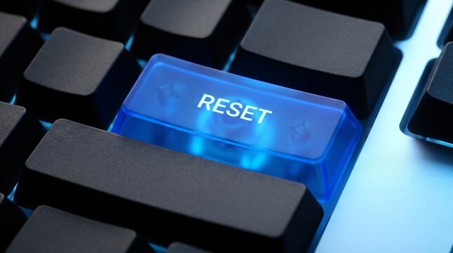 Glowing blue reset button on computer keyboard representing system restart or technology reboot concept.