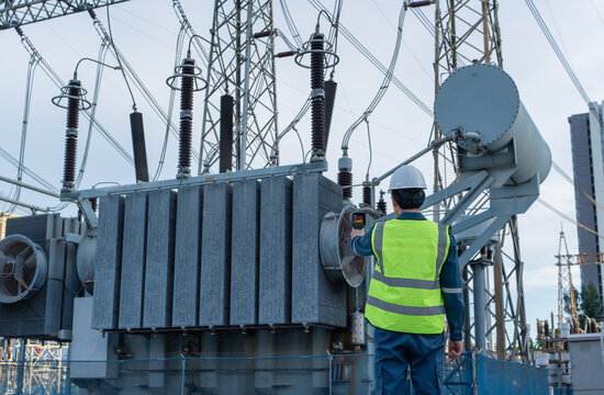 Engineer performs electrical safety inspection with a thermal camera on a power transformer in a high voltage substation, supporting fault detection and reliable operation.