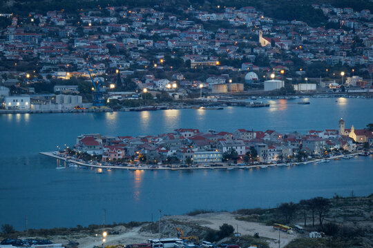 Twilight hues envelop the historic harbor of Split, Croatia, casting soft purple reflections across the Adriatic waters with the mountains framing the beautiful Dalmatian coastal shoreline
