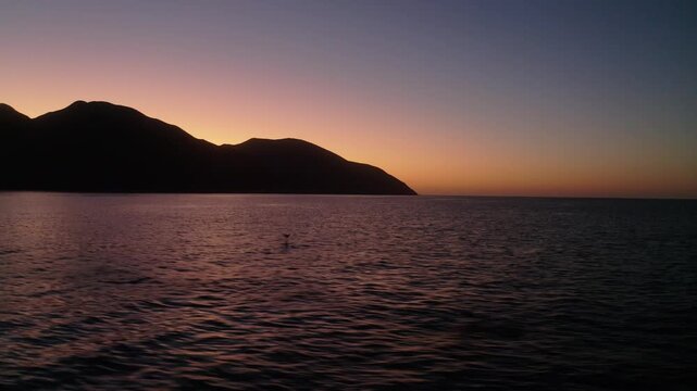 4K drone video of wild mobula rays jumping out of the sea water during a beautiful sunset in La Ventana, Baja California Sur.