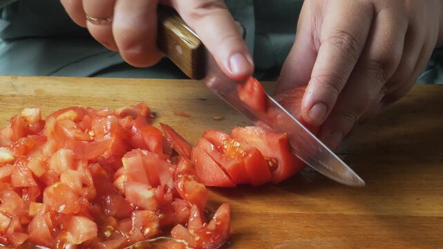 Slicing fresh red tomatoes with a knife on a cutting board