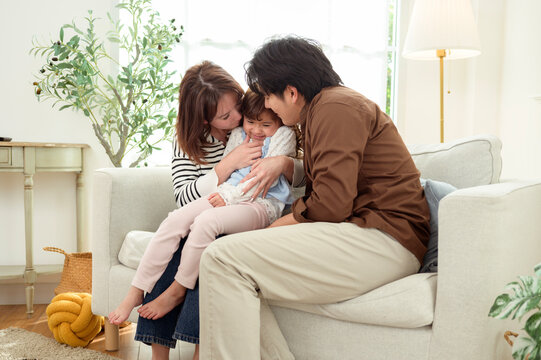 Family Plays Together in a Living Room on a Sofa