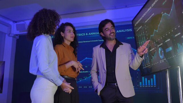 Business Team analyzing financial data in the office, discussing strategy with laptops and digital charts. The scene teamwork, fintech, data-driven decisions, innovation, and digital transformation.