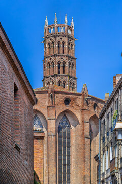 Street view of Jacobins Church apse and bell tower in Toulouse, France. Southern Gothic brick architecture under sky