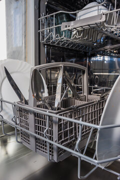 Close up of a dishwasher filled with dirty dishes. Dishwasher. Dishwasher filled with dishes. Washing dishwasher