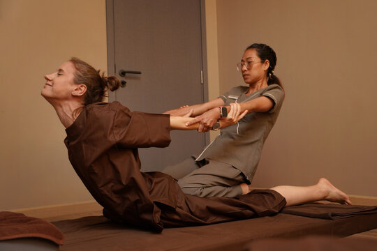 Young women in spa for relaxation and wellness treatment. Thai massage on the floor