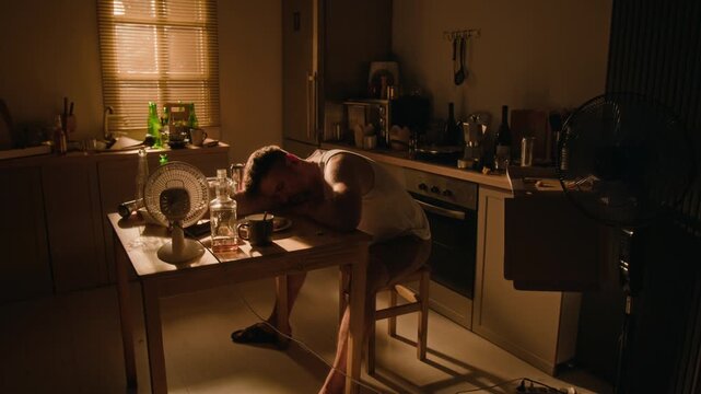 Intoxicated young adult Caucasian man sleeping on table near alcohol bottles. Scene suitable for addiction recovery campaigns, alcoholism awareness, and mental healthcare advertising