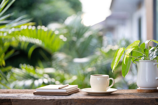 White ceramic coffee cup and stack of notebooks