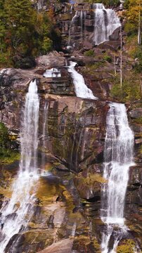Aerial view of Whitewater Falls in North Carolina surrounded by colorful autumn forest. Powerful waterfall cascades through Appalachian mountain wilderness.