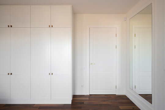White wardrobe cabinet near bedroom door