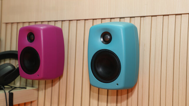 Studio monitor active speakers mounted on a wooden wall panel