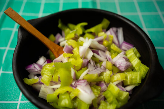Chopped Green Peppers and Red Onions Mix in Clay Bowl with Spoon