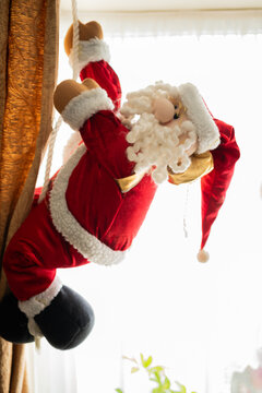 Close Up Plush Santa Claus Decoration Climbing Rope on Window Curtain