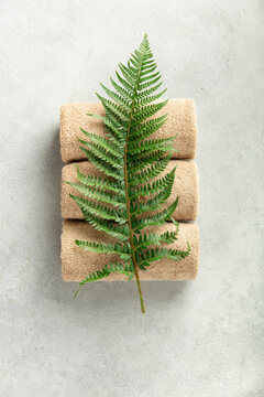 Spa Towels with Green Fern on Light Minimal Background