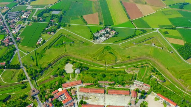 Palmanova, Udine, Italy. Drone footage of the nine-pointed star fortress, its concentric ramparts and geometric bastions visible from above amid green fields. Drone footage