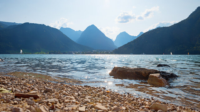 Small waves on Lake Achensee lap against the stony shore. view to the Karwendel mountains.
