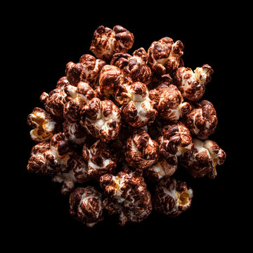 Chocolate popcorn cluster kernel coated in glossy golden caramel, isolated on black background, concept of gourmet snack food