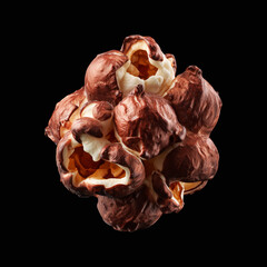 Obraz premium Chocolate popcorn cluster kernel coated in glossy golden caramel, isolated on black background, concept of gourmet snack food