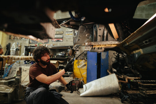 Mechanic repairing car frame in auto repair shop