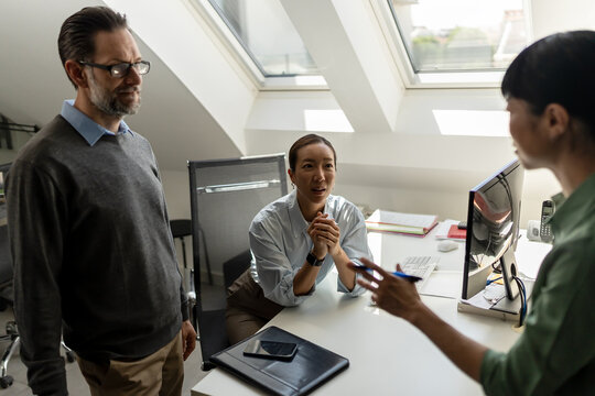 Business colleagues talking informally in the office, representing professional networking, workplace communication and positive working relationships