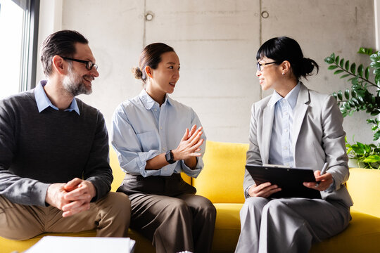 Couple talking with a real estate agent during a property consultation after viewing a modern apartment, discussing their potential new home.