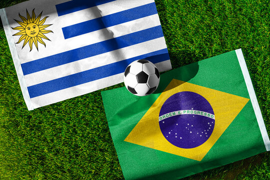 Uruguay vs Brazil football and soccer game background concept with national flags on green turf for South American championship
