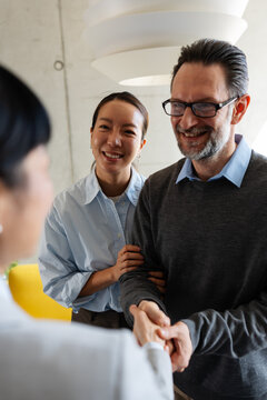 Happy couple shaking hands with a real estate agent after a successful property viewing, expressing satisfaction with their home buying experience